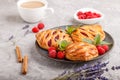 Puff pastry buns with strawberry jam on blue ceramic plate on gray concrete background. side view Royalty Free Stock Photo