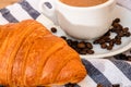 Puff pastry, coffee cup and buttered French croissant on wooden crate. Food and breakfast concept. Detail of coffee desserts and