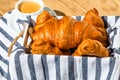 Puff pastry, coffee cup and buttered French croissant on wooden crate. Food and breakfast concept. Detail of coffee desserts and