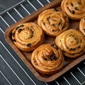 Puff pastry curls cinnamon raisin buns just baked. Fresh baked dough on tray just out of oven. Sweet pastries and Royalty Free Stock Photo
