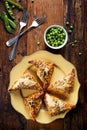 Puff pastry filled with green peas and cheese on a wooden table Royalty Free Stock Photo