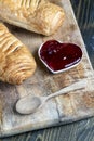 puff pastry with red strawberry jam on a wooden table Royalty Free Stock Photo