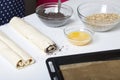 Puff pastry rolled into a tube. Filled with poppy and walnuts. For making curls. Nearby on the table are ingredients and tools