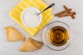 Puff pastry, tea, sugar in bowl on napkin, cinnamon sticks Royalty Free Stock Photo