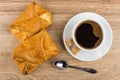 Puff pies with filling, coffee, sugar on saucer, spoon