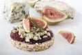 Puffed exploded wheat grains with slices of figs and blue cheese on a thin layer of jam