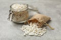 Puffed rice in jar and sack on light grey table, closeup Royalty Free Stock Photo