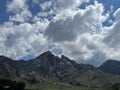 Puffy clouds over mountain peaks Royalty Free Stock Photo