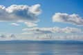 Puffy cumulous clouds billowing across a blue sky Royalty Free Stock Photo