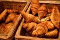 Puffy golden brown Croissants in sales wicker baskets, freshly baked, with natural lighting