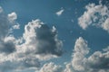 Puffy white clouds framed by intense blue sky and subtle sun rays Royalty Free Stock Photo