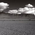 Puffy white clouds mountain side and dry desert sand background abstract Royalty Free Stock Photo