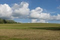 Puffy White Clouds over a Farm Hillside Royalty Free Stock Photo