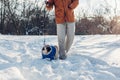 Pug dog walking on snow with man. Puppy wearing winter coat Royalty Free Stock Photo