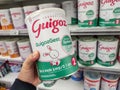 A consumer chooses a box of Guigoz brand baby milk from the baby food section of a supermarket
