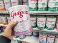 A consumer chooses a box of Guigoz brand baby milk from the baby food section of a supermarket