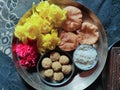 Puja tali decorat with khir puri ladoo and yellow pink flowers