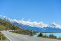 Men biking on the roadside on the lake Pukaki. The background is mount cook