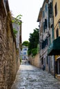 Pula, Croatia; 7/18/2019: Vertical picture of a narrow colorful stone street in the old town of Pula, Croatia, with steps at the