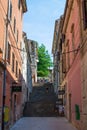 Pula, Croatia; 7/18/2019: Vertical picture of a narrow colorful street in the old town of Pula, Croatia, with steps in the center