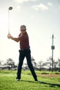 Pull back and swing. a focused young male golfer about to swing and play a shot with his golf club outside on a course. Royalty Free Stock Photo