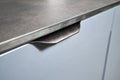 Pull out rack cabinet drawer handle closeup. Flush up slip handle finger pull profile handle of contemporary kitchen