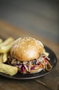 Pulled pork and coleslaw salad burger sandwich with fries meal
