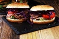 Pulled pork sandwiches with BBQ sauce, cabbage and tomato on tab Royalty Free Stock Photo