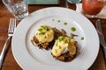 Pulled pork served on fried potato pancakes topped with poached egg and garnished with hollandaise sauce and fresh green onion aka Royalty Free Stock Photo