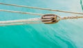 Pulley with nautical ropes of a classic sailing boat and blue sea water Royalty Free Stock Photo