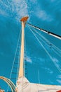 pulley with a rope on a classic sailing boat and a background of blue water. Detailed view of the classic mast of a Royalty Free Stock Photo