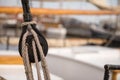 Pulley for sails and ropes made from wood on an old sail boat, with sail and other boats out of focus in the background. Royalty Free Stock Photo