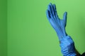 Pulling a blue medical glove over a hand
