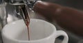 Pulling espresso shot with single spout portafilter from coffee machine closeup