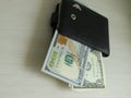 Pulling focus on a folded and very used wallet with cards and cash on a table with a blurry background Royalty Free Stock Photo