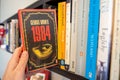 Pulling Orwell`s 1984 off a bookshelf Royalty Free Stock Photo