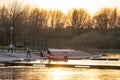 Pulling speedboat out of lake up boat ramp with sailing rope. Sunset and golden light reflecting on water. Powerboat engine back Royalty Free Stock Photo