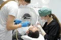 pulling a tooth extracting teeth in dentistry middle aged two women nurse and doctor bent over a patient in a dental