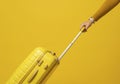 Pulling Yellow Suitcase Rolling Travel Bag on Yellow Background Royalty Free Stock Photo