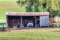 An old rusted pickup truck in a shed on a farm