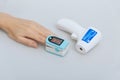 Pulse oximeter and thermometer gun on white background. Measuring oxygen saturation, pulse rate and oxygen levels