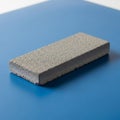 Pumice stone on a blue surface showcasing its porous texture Royalty Free Stock Photo