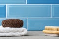 Pumice stone, brush and towel on shelf in bathroom Royalty Free Stock Photo