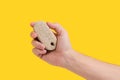 Pumice stone for cleaning feet and heels, in hand on yellow background. Royalty Free Stock Photo