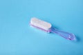 Pumice stone with pink plastic handle and pedicure brush on blue background, smooth skin of the foot Royalty Free Stock Photo