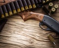 Pump action shotgun, 12 guage cartridge and ramrod on the wooden table Royalty Free Stock Photo