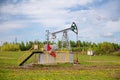 Pump jack with a green field in background