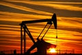 Pump jack in the oil field at sunset Royalty Free Stock Photo