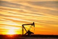 Pump jack in the oil field at sunset Royalty Free Stock Photo