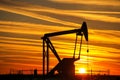 Pump jack in the oil field at sunset Royalty Free Stock Photo